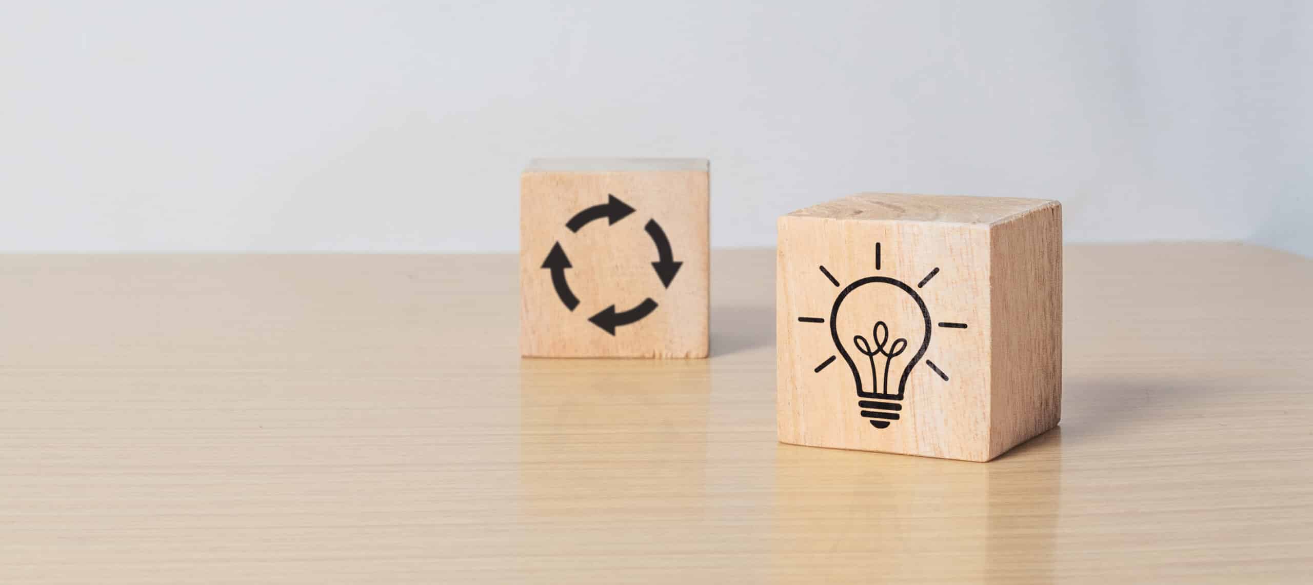 Wooden cube blocks with light bulb and cycle icons. Creative idea, solution and innovation concept. Idea generation for business development. clean background and copy space