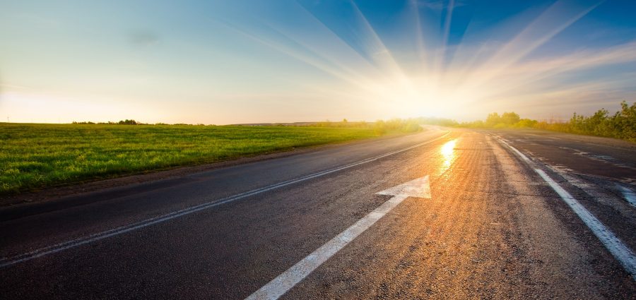 black asphalt road with arrow to sunset