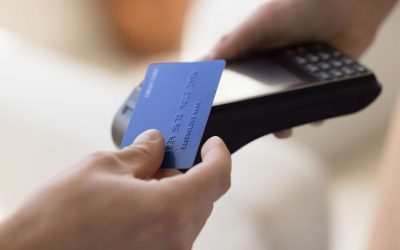 Close up crop view unknown male makes easy, convenient e-payment, holds plastic card against contactless payment terminal equipment, paying for services, food or shopping use wireless NFC technology