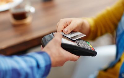 Close-up of unrecognizable customer choosing contactless payment using credit card while waitress accepting payment over nfc technology