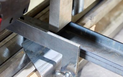 operator holding a metal part on metal bending machine.