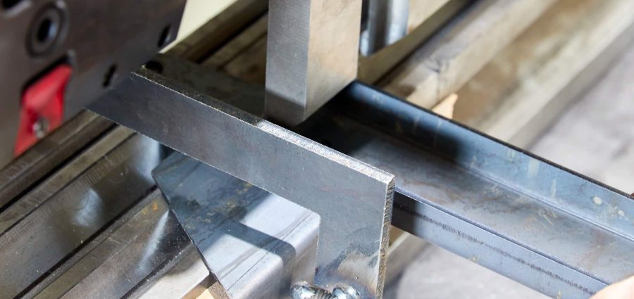 operator holding a metal part on metal bending machine.