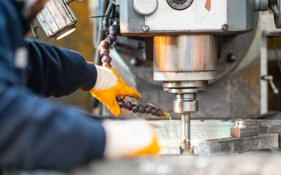 A worker in a factory working on a traditional milling machine