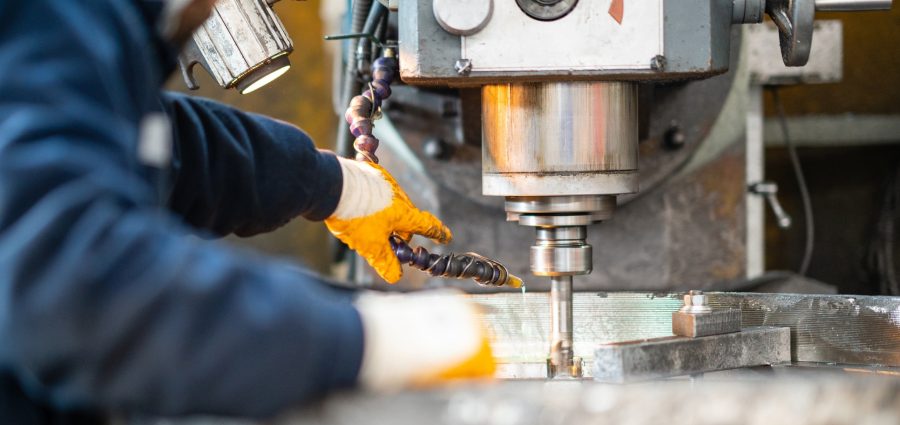 A worker in a factory working on a traditional milling machine