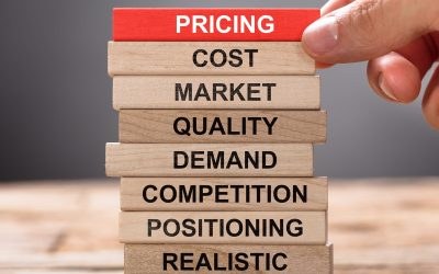 Closeup of hand building pricing concept with wooden blocks on wood
