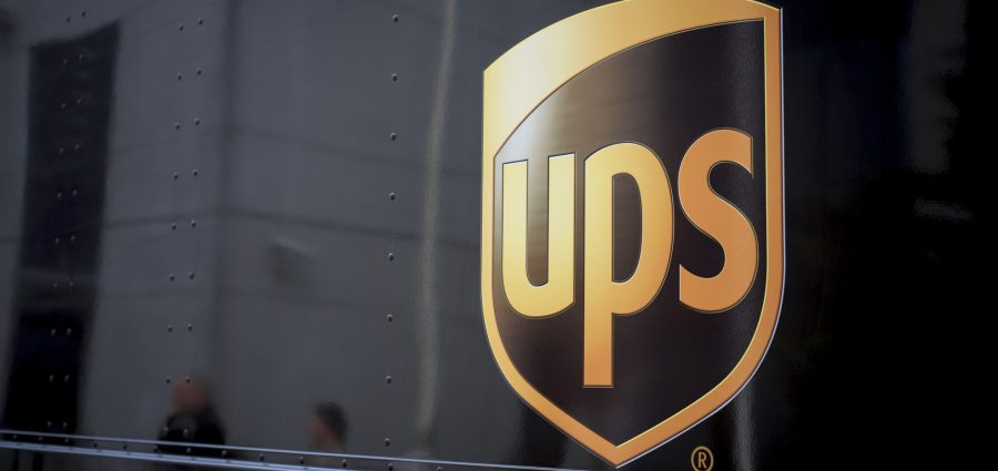 "Amsterdam, The Netherlands - March 29, 2012: Parked UPS delivery van. Branded UPS on side of van. Downtown Amsterdam with blurry people mirrored in the background."