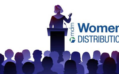 Female Public Speaker On Lectern In Front Of Audience.