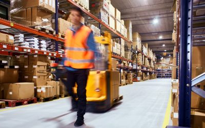 Warehouse, worker with a forklift in motion blur.