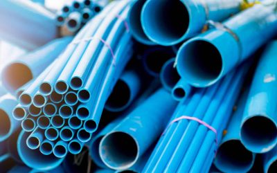 Selective to blue plastic pipe background. PVC pipes stacked in warehouse of construction site.  PVC water pipes used for construction.