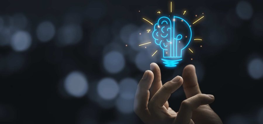 Hand holding drawing virtual lightbulb with brain on bokeh background for creative and smart thinking idea concep