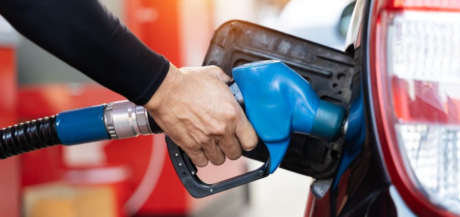 Refueling the car at a gas station fuel pump. Man driver hand refilling and pumping gasoline oil the car with fuel at he refuel station. Car refueling on petrol station. Fuel pump at station