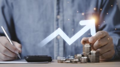 Businessman hand drawing virtual increasing graph with money coins stacking , Business investment profit and deposit dividend saving growth concept.