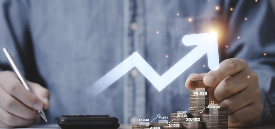Businessman hand drawing virtual increasing graph with money coins stacking , Business investment profit and deposit dividend saving growth concept.