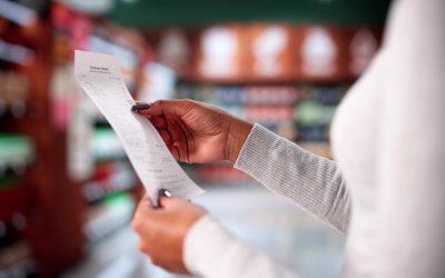 Woman Checking Grocery Store Receipt After Shopping At Supermarket Aisle. Possible Professions: Cashier, Accountant