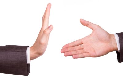 Businessman hands, one of reaching for handshake, the other gesturing stop sign, isolated on white background.