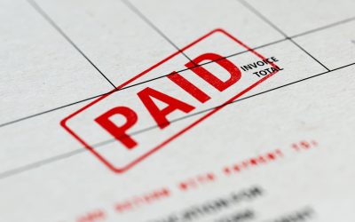 Close-up picture of an invoice with red paid stamp with selective focus. Great use for financial concepts.